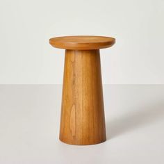 a small wooden stool sitting on top of a white table