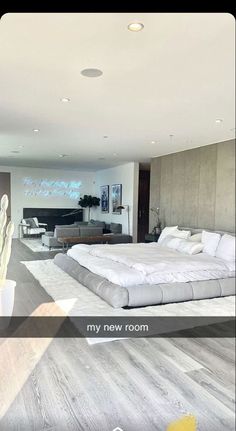 a large bed sitting in the middle of a bedroom next to a living room filled with furniture