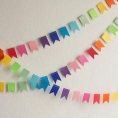 multicolored paper buntings are hanging on the wall