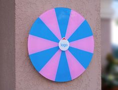 a blue and pink umbrella mounted to the side of a building's exterior wall