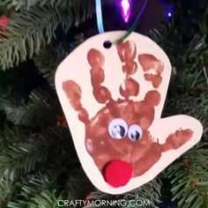 a handprint ornament hanging from a christmas tree