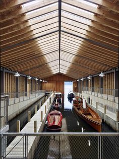 two boats are docked in the water under a wooden roof