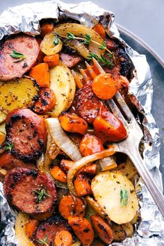 a plate with sausage, potatoes and carrots on it