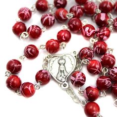 Features: Ruby Red color with swirl effect on beads Heart medallion with Fatima imagery on both sides Rosary measures 23" Diameter of the beads: 7 mm Made in Fatima, Portugal Product Description: Celebrate our Lady of Fatima with this beautiful ruby red glass rosary. Hand made in Fatima, Portugal, this rosary is a great way to commemorate Our Lady of Fatima. A classic handmade rosary and Fatima medallion to commemorate Mary's apparitions in Portugal. Fatima Portugal, Ruby Red Color, Handmade Rosary, Lady Of Fatima, Catholic Rosary, Rosary Catholic, Red Glass, Our Lady, Ruby Red