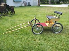 an old fashioned cart with two seats on the grass