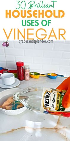 a bottle of vinegar sitting on top of a counter next to bowls and utensils