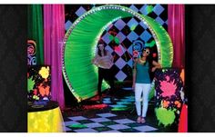 a woman standing in front of a stage with neon lights and decorations on the walls