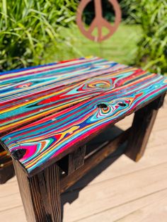 a wooden bench sitting on top of a wooden floor next to green grass and trees