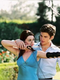 a young man and woman are aiming an arrow at something in the air with their hands