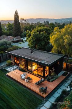 an aerial view of a house with a deck and patio in the backyard at sunset