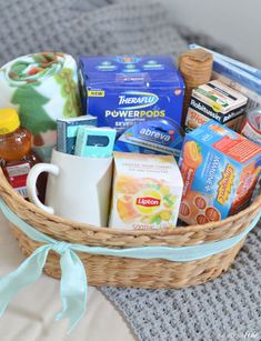 a basket filled with lots of different types of items on top of a bed next to a pillow