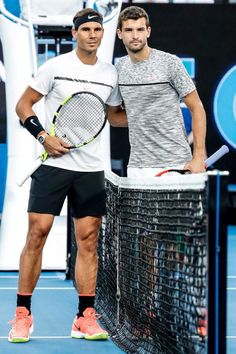 two tennis players standing next to each other holding rackets