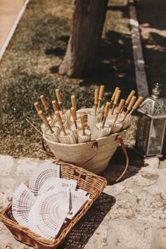 a basket full of matches sitting on the ground next to a table with plates and napkins