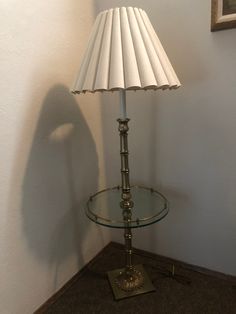 a lamp that is sitting on top of a glass table next to a framed picture