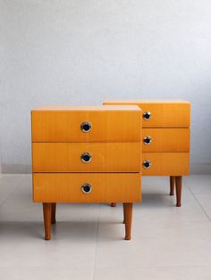 two wooden dressers sitting next to each other on top of a white tile floor