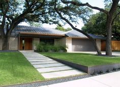 a house with trees and grass in the front yard