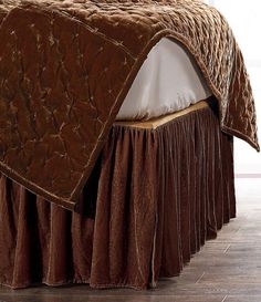 a bed with a brown bedspread on top of it