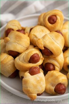 a white plate topped with pigs in a blanket cookies covered in crescented hot dogs