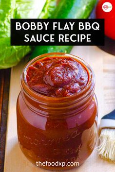 a jar filled with bbq sauce sitting on top of a cutting board next to lettuce