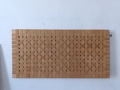 a piece of wood that has been made into a wall hanging on the side of a white wall