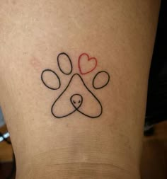 a dog's paw and heart tattoo on the leg