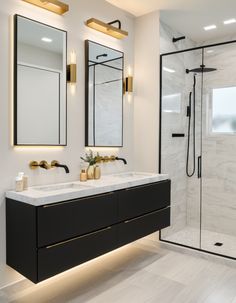 a bathroom with two sinks, mirrors and a walk - in shower next to it