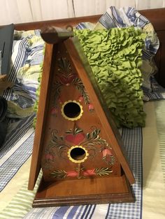 a wooden birdhouse with two holes in it