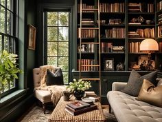 a living room filled with furniture and bookshelves next to a window covered in lots of books