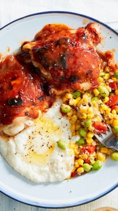 a plate with meat, mashed potatoes and corn on it next to a fork