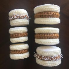 four crocheted macaroni and cheese pastries are arranged in the shape of hamburgers