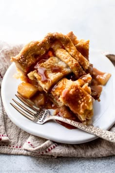 a piece of apple pie on a plate with a fork