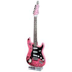 a pink and black electric guitar with hello kitty on it's neck, standing upright