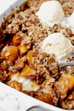 a close up of a dish of food with ice cream on top and fruit in the background