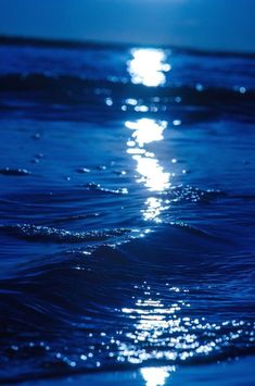 the moon shines brightly in the ocean water as it reflects on the surface of the water