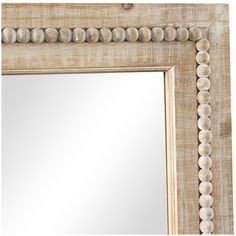 a white framed mirror with shells on the edge and beading around it's edges