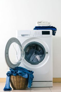 a washer and dryer sitting next to each other on the floor in front of a white wall