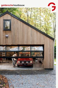 a car is parked in front of a garage with two people sitting at the table