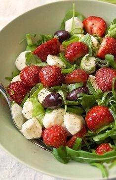 a salad with strawberries, olives and mozzarella