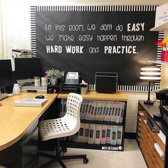 an office with a chalkboard on the wall that says in this room we don't do easy work, happen through hard work and practice