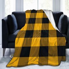 a black and yellow checkered blanket sitting on top of a couch