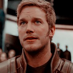 a close up of a person wearing a leather jacket and looking at the camera with an intense look on his face