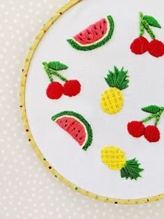 a embroidery project with fruits and berries on white fabric, including pineapples, watermelon, cherries, strawberries