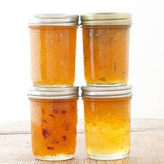 four jars filled with food sitting on top of a table