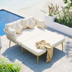 a white couch sitting next to a swimming pool