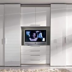 an entertainment center with white cabinets and a television on it's wall, in the middle of a living room