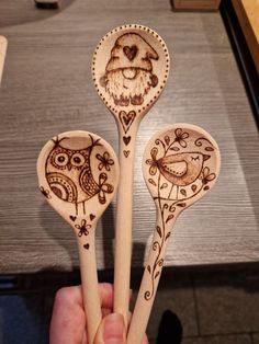 three wooden spoons with designs on them