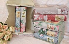 a stack of books sitting on top of a table next to a vase filled with flowers