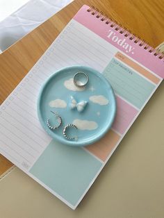 a blue plate with two rings on top of it next to a notepad and pen