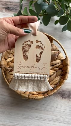 a person is holding a baby's hand and foot print ornament in a basket