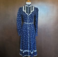 Vintage Navy Blue Calico Button Down High Neck Collared Long Sleeve Dress. Buttons Go All The Way Down. Slight Puff To The Shoulders. Buttons At The Wrists. Velvet On The Chest. Lace Detailing Throughout. Ties Behind The Back. Tagged As A 9; Fits Like A 2/4. Excellent Condition. Like The Item But Not The Price?? I Accept All Reasonable Offers! Plus Recieve Free Shipping On Orders $50+ And 10% Off Bundles Of 2 Or More! Gunny Sack Dress, Gunne Sax Dress, Dress Buttons, Gunne Sax, Prairie Dress, Neck Collar, Lace Detail, Sleeve Dress, Dresser